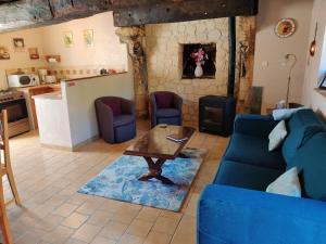 a living room with a blue couch and a table at La Source in Sermaise