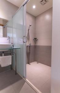 La salle de bains est pourvue d'une douche et d'un lavabo. dans l'établissement Lane 523埔里包棟庭園民宿, à Puli