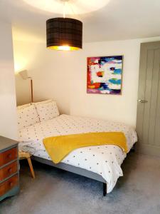 a bedroom with a bed and a painting on the wall at Brecon Burrows in Dowlais