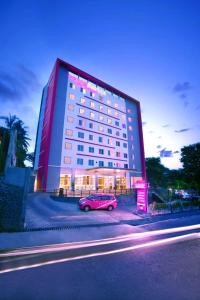 a pink car parked in front of a large building at favehotel Padjajaran Bogor in Bogor
