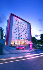 茂物的住宿－茂物帕德加加蘭法維酒店，停在大楼前的粉红色汽车