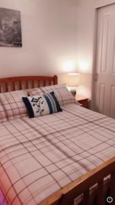 a bedroom with a bed with a red and white blanket at Comfy Home in Aberdeen