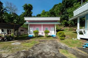 uma casa rosa no meio de um quintal em OYO 1133 Koh Chang Baantalay Resort em Ko Chang