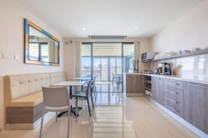 
a kitchen with a dining room table and chairs at Port View Guesthouse in Marsaxlokk
