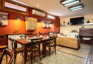 a dining room with a table and chairs and a couch at Los Canteros in Golmayo