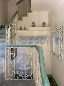 eine Treppe mit einem Tor und einem Spiegel in der Unterkunft Il Pozzetto Home Resort in Pietrasanta