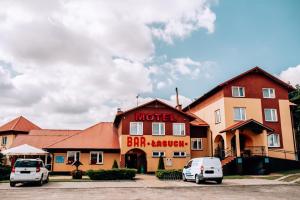 ein Hotel mit zwei davor geparkt in der Unterkunft Motel Łasuch in Osjaków