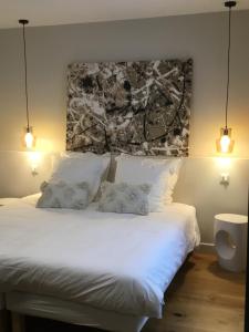 a bedroom with a white bed with two pillows at Les Chambres d'Andrea in Marseillan