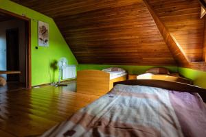 een slaapkamer met 2 bedden en een groene muur bij Agroturystyka u Julii in Helusz