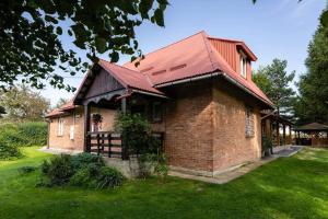 een stenen huis met een rood dak bij Agroturystyka u Julii in Helusz