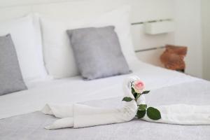 un letto bianco con una rosa sopra di Villa Aurora B&B a Bari