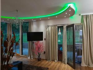a living room with a green light on the ceiling at Вила МАЯ in Krayni Dol