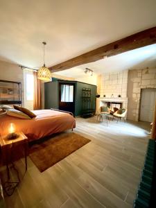 a bedroom with a large bed and a fireplace at La Gouronerie in Parçay-sur-Vienne