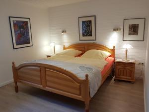 uma grande cama de madeira num quarto com 2 candeeiros em Haus Inge Ysker em Greetsiel