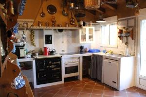 cocina con electrodomésticos blancos y suelo de baldosa marrón en Casa Rural Rincon de la Vega en Los Cortos