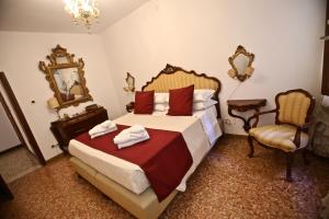 威尼斯的住宿－Ca Donzela，一间卧室配有一张床、一把椅子和镜子