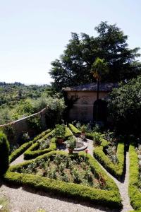 un jardín con setos y plantas y un edificio en Villa La Strega, en Siena