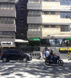 two people riding a motorcycle on a city street at Hotel Ruiseñor Itagui in Itagüí