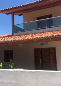 a house with a balcony on top of it at Casa de praia Luiz Correia paraíso azul in Luis Correia