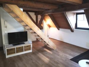 a living room with a flat screen tv and a staircase at Appartement 1856 in Landsberg am Lech