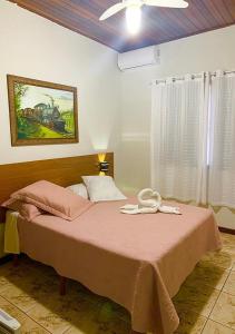 JacarèzinhoにあるHotel Avenidaのベッドルーム1室(ピンクの毛布付きのベッド1台付)