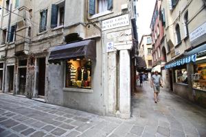 a man walking down a street next to a building at Ca Donzela in Venice