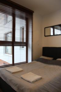 a bedroom with a bed with two towels on it at Apart Prestige Ząbkowska Old Town in Warsaw