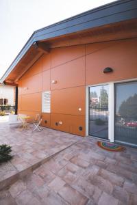 an orange building with a patio and a table at B&B OASI in Ronchi dei Legionari