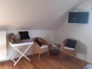a room with two chairs and a table with a keyboard at Het Meikenshof in Dentergem