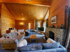 a living room with couches and a stone fireplace at The Dorset Resort in East Stoke