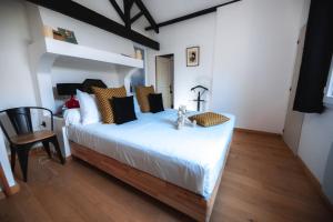 a bedroom with a white bed with a teddy bear on it at Villa Kumquats in Béziers