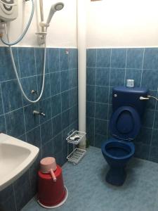 bagno con servizi igienici blu e lavandino di Homestay Bandar Batu Pahat a Batu Pahat