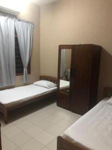 a bedroom with two beds and a mirror in it at Homestay Bandar Batu Pahat in Batu Pahat