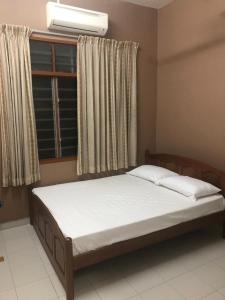 1 cama en un dormitorio con ventana en Homestay Bandar Batu Pahat en Batu Pahat