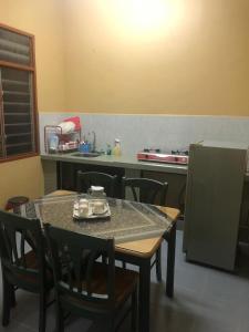 cocina con mesa, sillas y barra en Homestay Bandar Batu Pahat en Batu Pahat