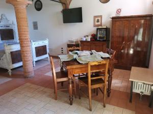 a dining room with a wooden table and chairs at Casa Flosa Room & Breakfast in Medicina