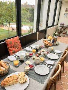 - une table avec des assiettes de nourriture et de pain dans l'établissement Maison d'Hôtes Joussaume Latour, à Château-Thierry