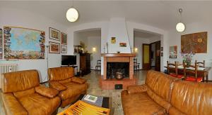 - un salon avec des canapés en cuir brun et une cheminée dans l'établissement B&B Casa Certosa, à Sienne