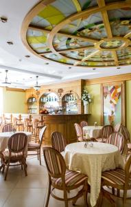 un restaurante con mesas y sillas y un techo colorido en Becker Hotel, en Yantarny