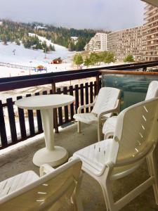 a table and chairs on a balcony with a view of the beach at Super Dévoluy, Résidence le Bois D'Aurouze in Le Dévoluy