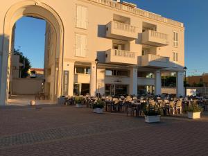 a building with tables and chairs in front of it at Appartamento Sabbia & Conchiglie in Marotta