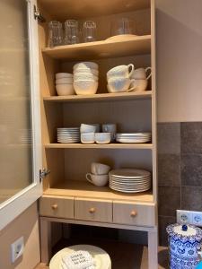 a cupboard with plates and bowls and dishes in it at Emmerglück Lügde in Lügde