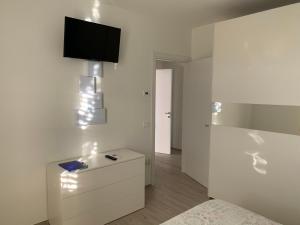 a bedroom with a bed and a tv on a wall at Appartamento Sabbia & Conchiglie in Marotta