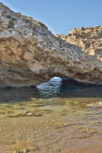 een rotsgrot in het water bij het strand bij B&B Villa Sara Falconara in Licata