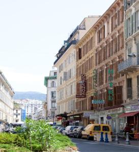 a city street with parked cars and buildings at Hotel d'Ostende in Nice