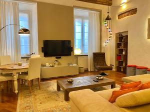 ein Wohnzimmer mit einem Sofa und einem Tisch in der Unterkunft Kindness art apartment in historic center in Arona