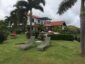 a house with two chairs and a table in the yard at Hawk's Nest Bed & Breakfast in La Laguna de San Carlos