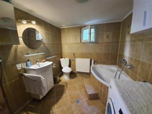 uma casa de banho com uma banheira, um WC e um lavatório. em Tudor View em Sinaia
