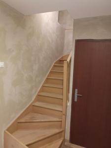- un escalier en bois avec une porte en bois dans la chambre dans l'établissement Duplex cozy, à Montigny-lès-Metz