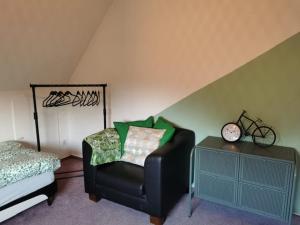 a bedroom with a chair and a bed and a clock at Heide Schnack in Soltau